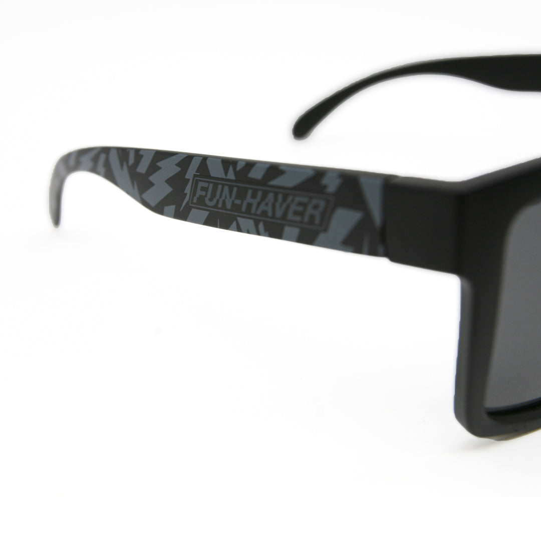 Up close detail shot of Fun-Haver Dark Storm Striker Sunglasses with matte black design and printed contrasting lightning bolts