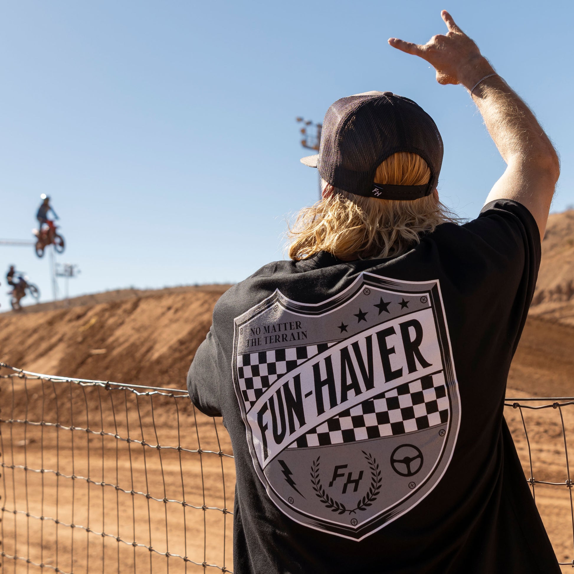 Back view of a rider wearing the Black Fun-Haver® Shield Logo T-Shirt at the track