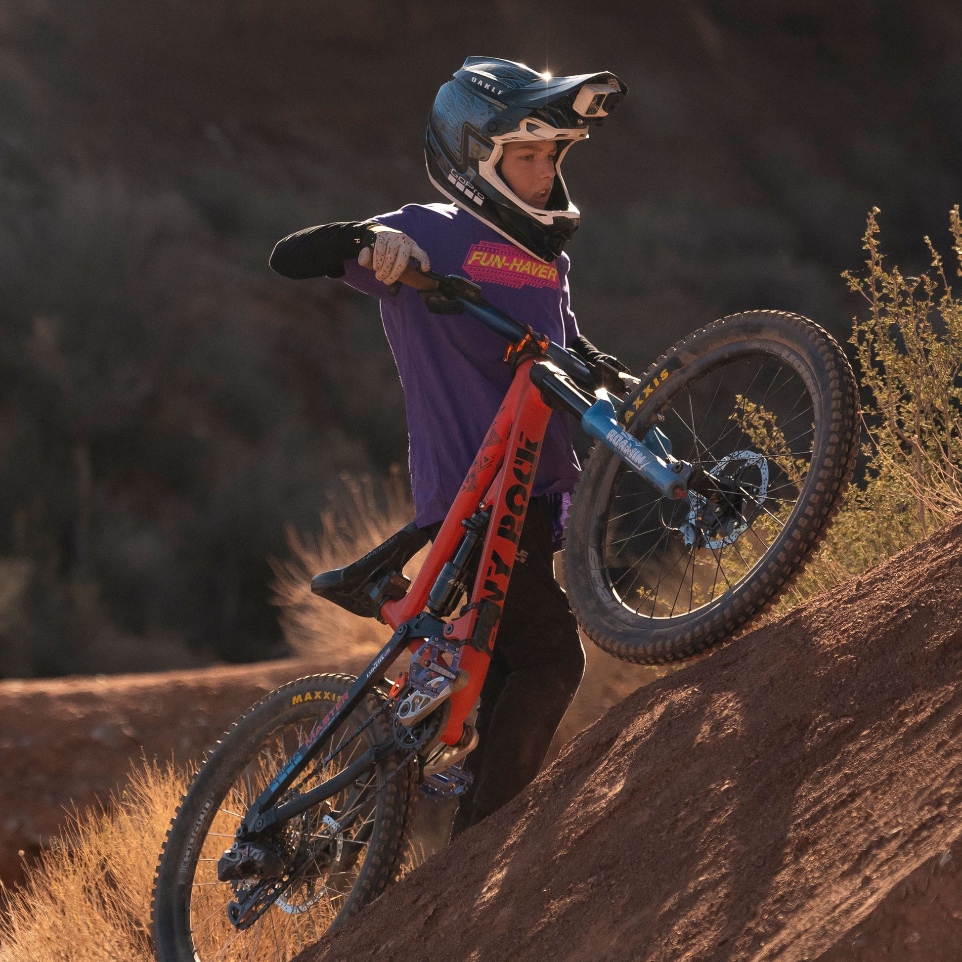 Future lifelong Fun-Haver wearing the Fun-Haver Purple Rush Pursuit Youth T-Shirt with Magenta and Yellow Fun-Haver logo graphics out in the desert in pursuit of fun