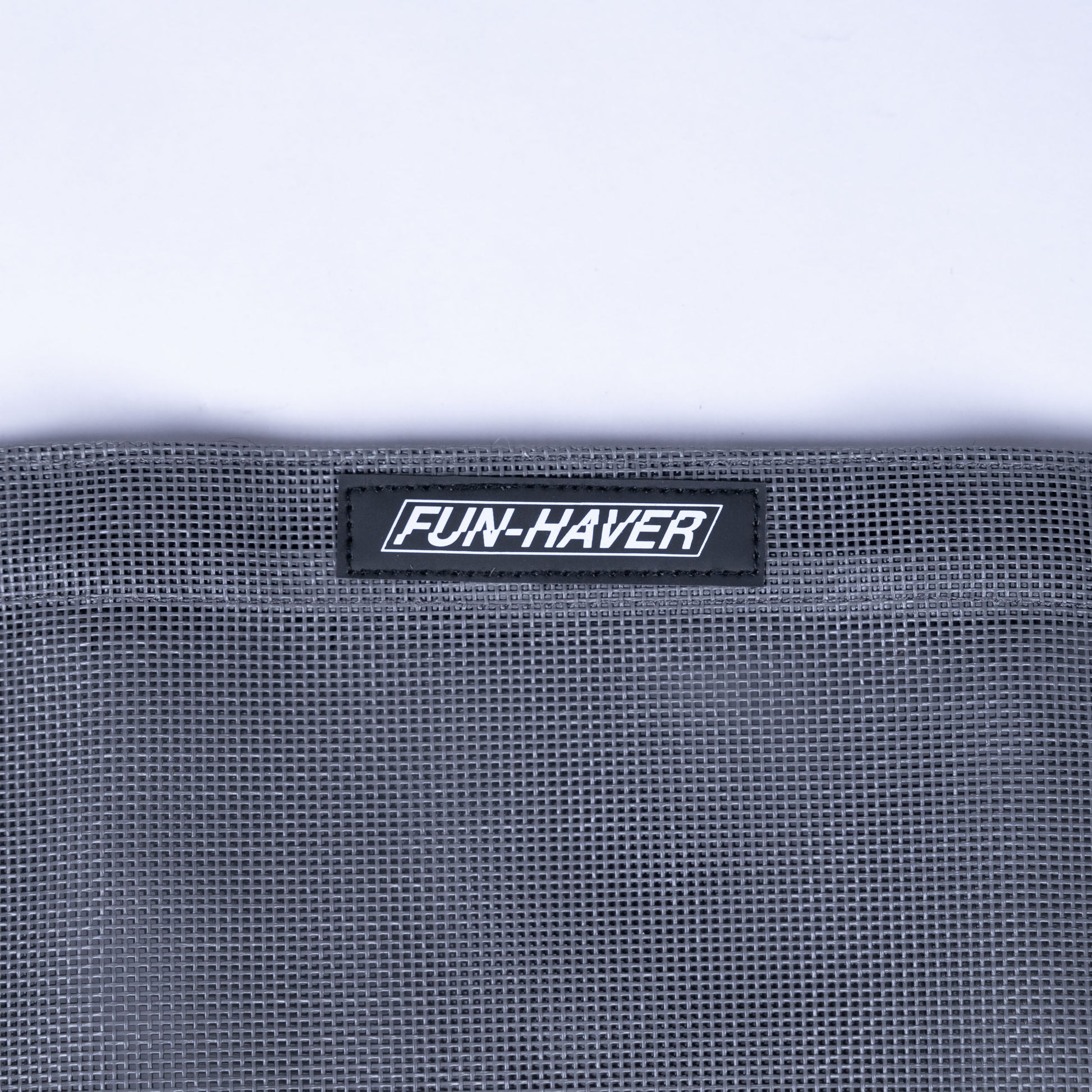 Detail view of the Grey Fun-Haver Trail Bag stitched on Fun-Haver logo tag.