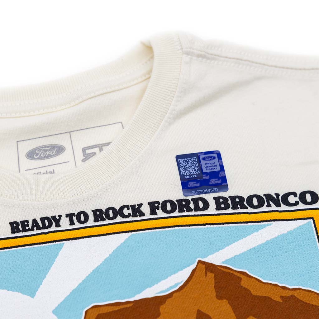 White youth shirt with 'Ready to Rock Ford Bronco' text and mountain graphic, featuring Ford branding.