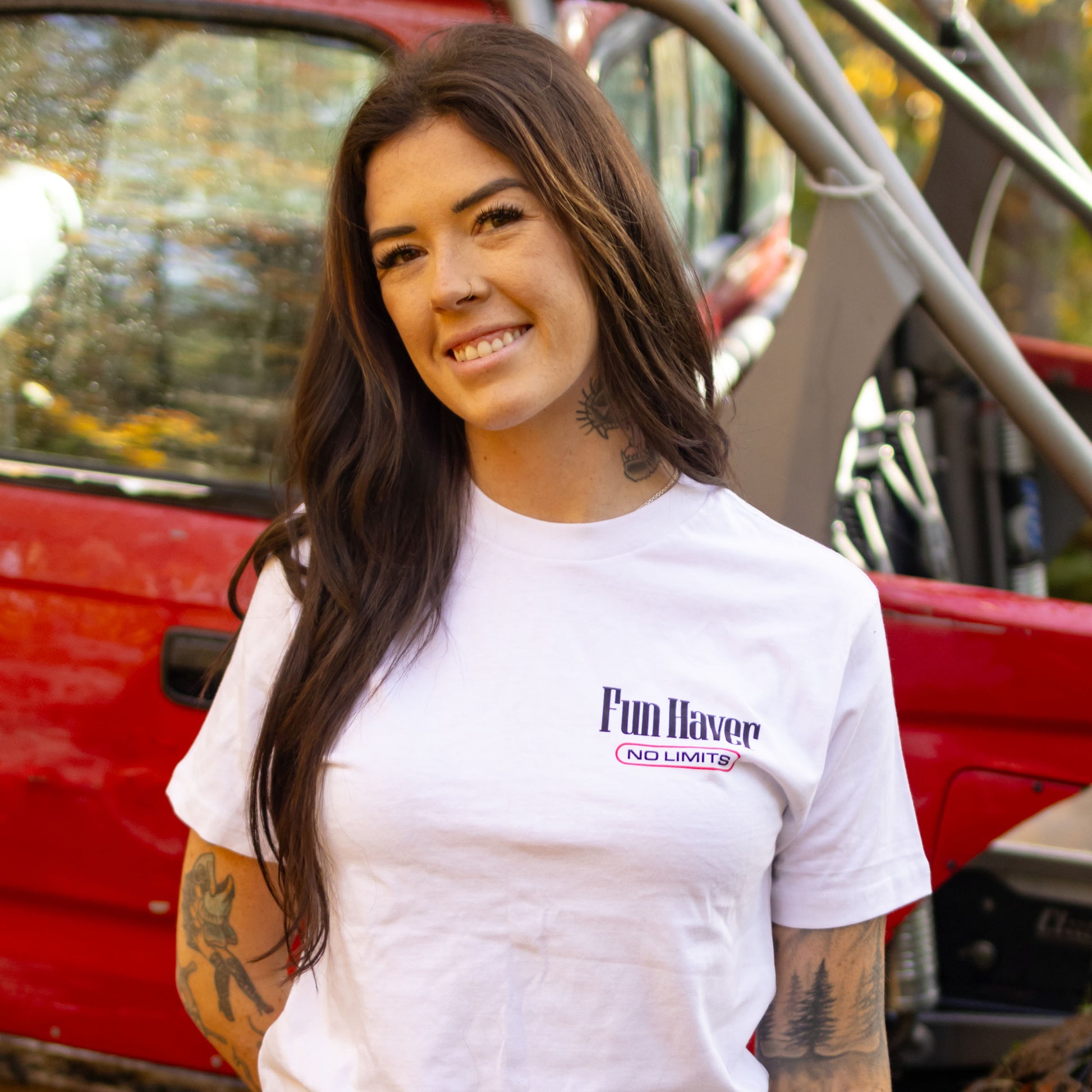 Front view of Kelsie Heck wearing the Fun-Haver No Limits White T-Shirt in front of her Toyota Tacoma truck.