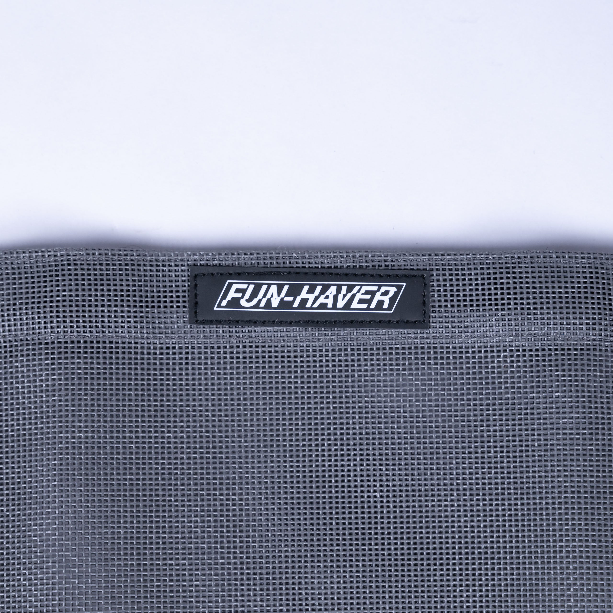 Detail view of the Grey Fun-Haver Trail Bag stitched on Fun-Haver logo tag.