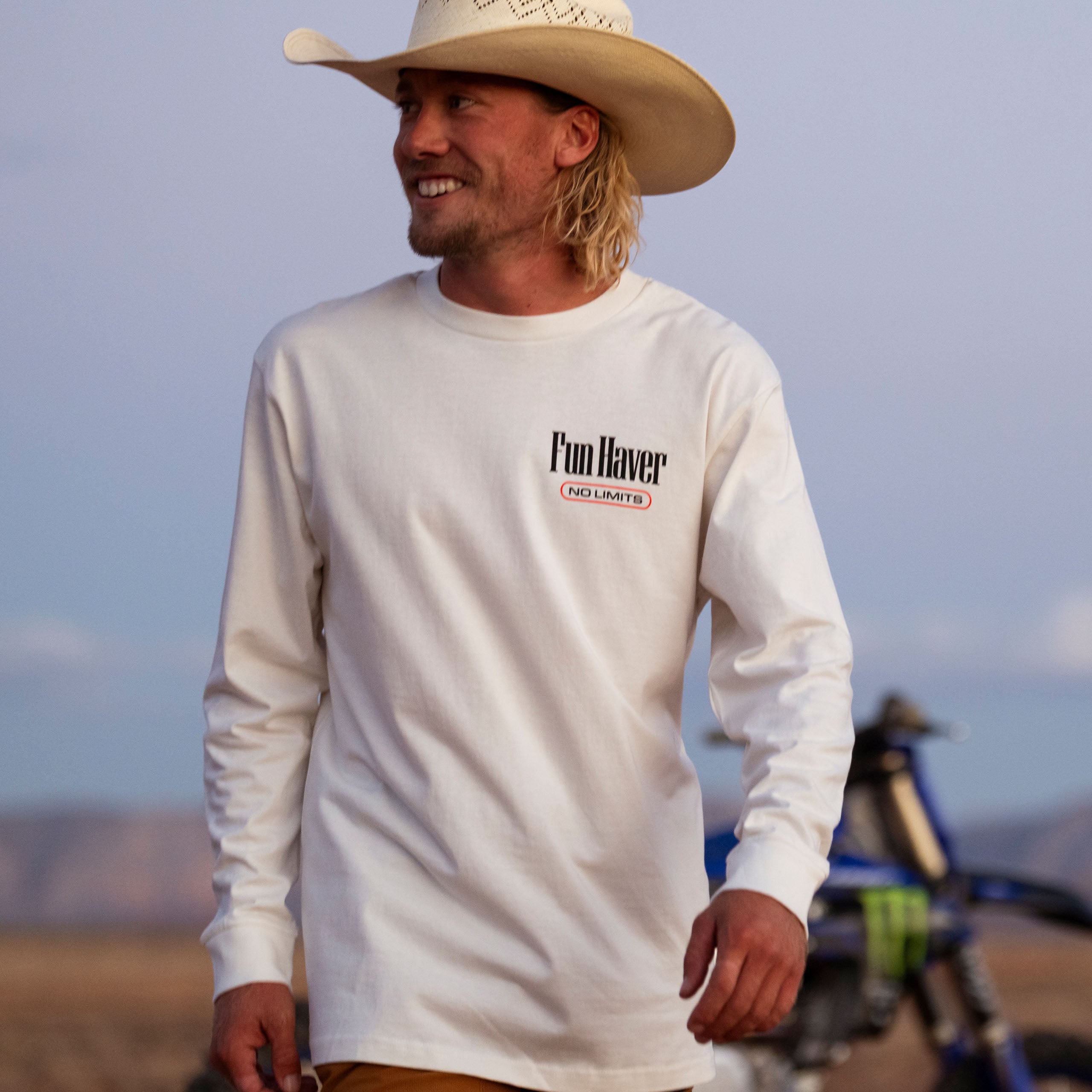 Front view of a motocross rider with a cowboy hat wearing the Fun-Haver No Limits White Long Sleeve T-Shirt.