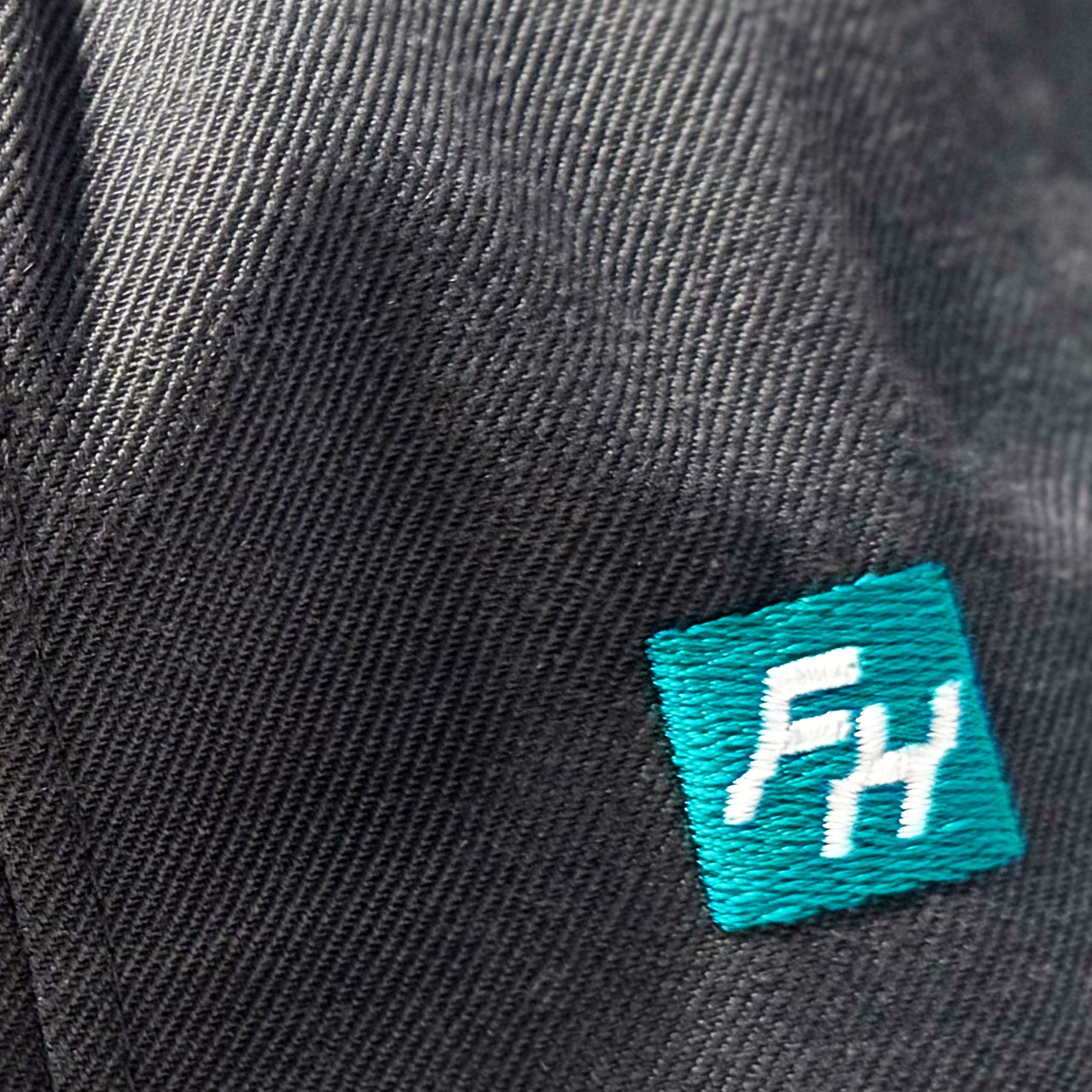 Close up detail of Fun-Haver woven logo on the Fun-Haver Grey No Limits Snapback Hat.