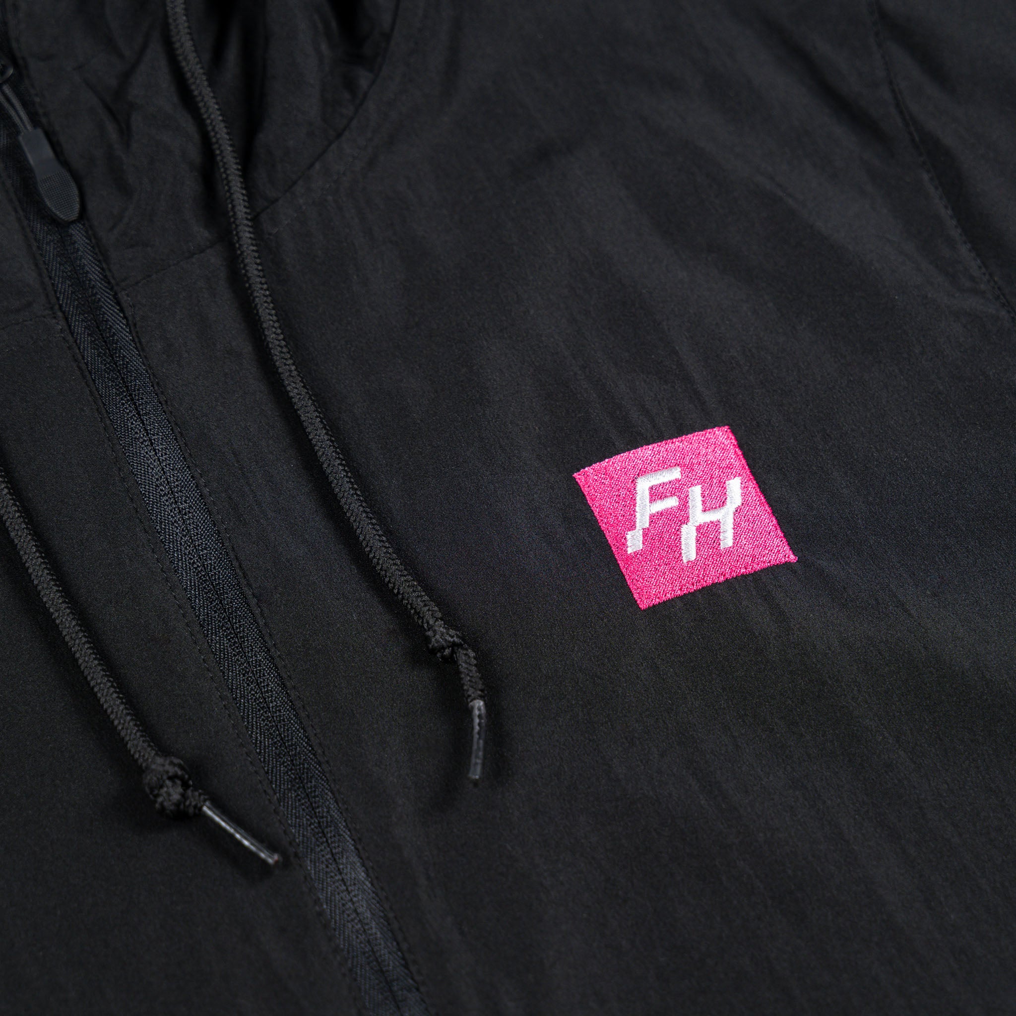 Chest detail view of the Black Fun-Haver Energy Windbreaker Anorak Jacket.