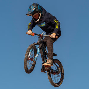 Wes wearing the Fun-Haver Midnight Navy Pursuit Youth Pullover Hoodie airborne bike action.