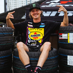 Ben Hobson wearing his 2026 RTR Drift Team Black T-Shirt sitting on top of a stack of Nitto tires.